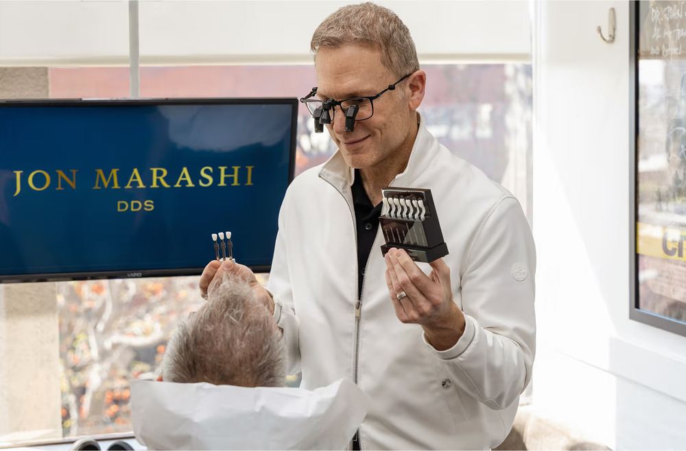 Dr. Marashi holding up tooth colors to patient